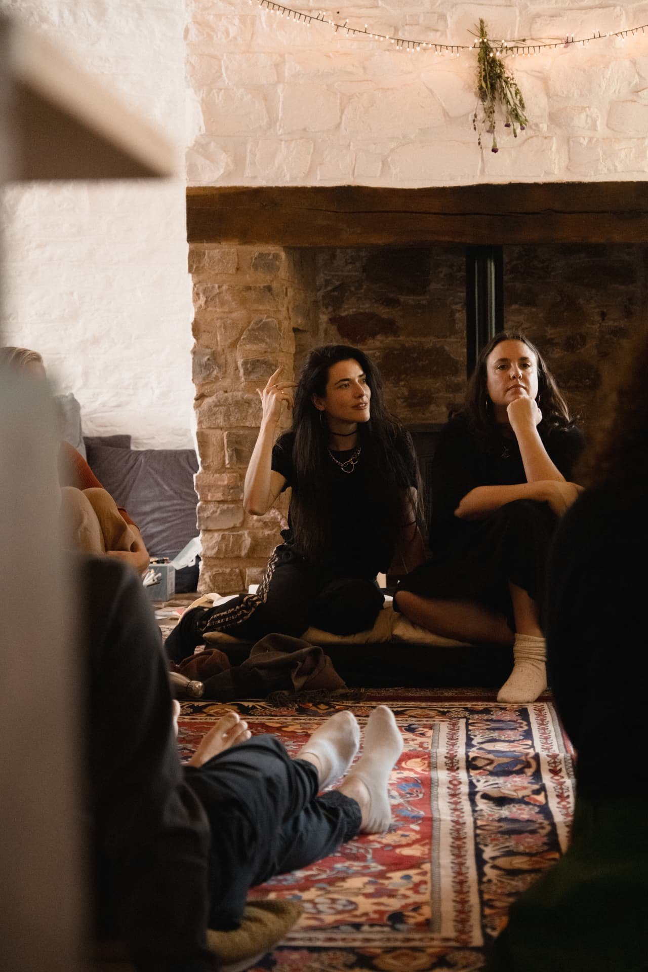 Two women seated in circle, one speaking