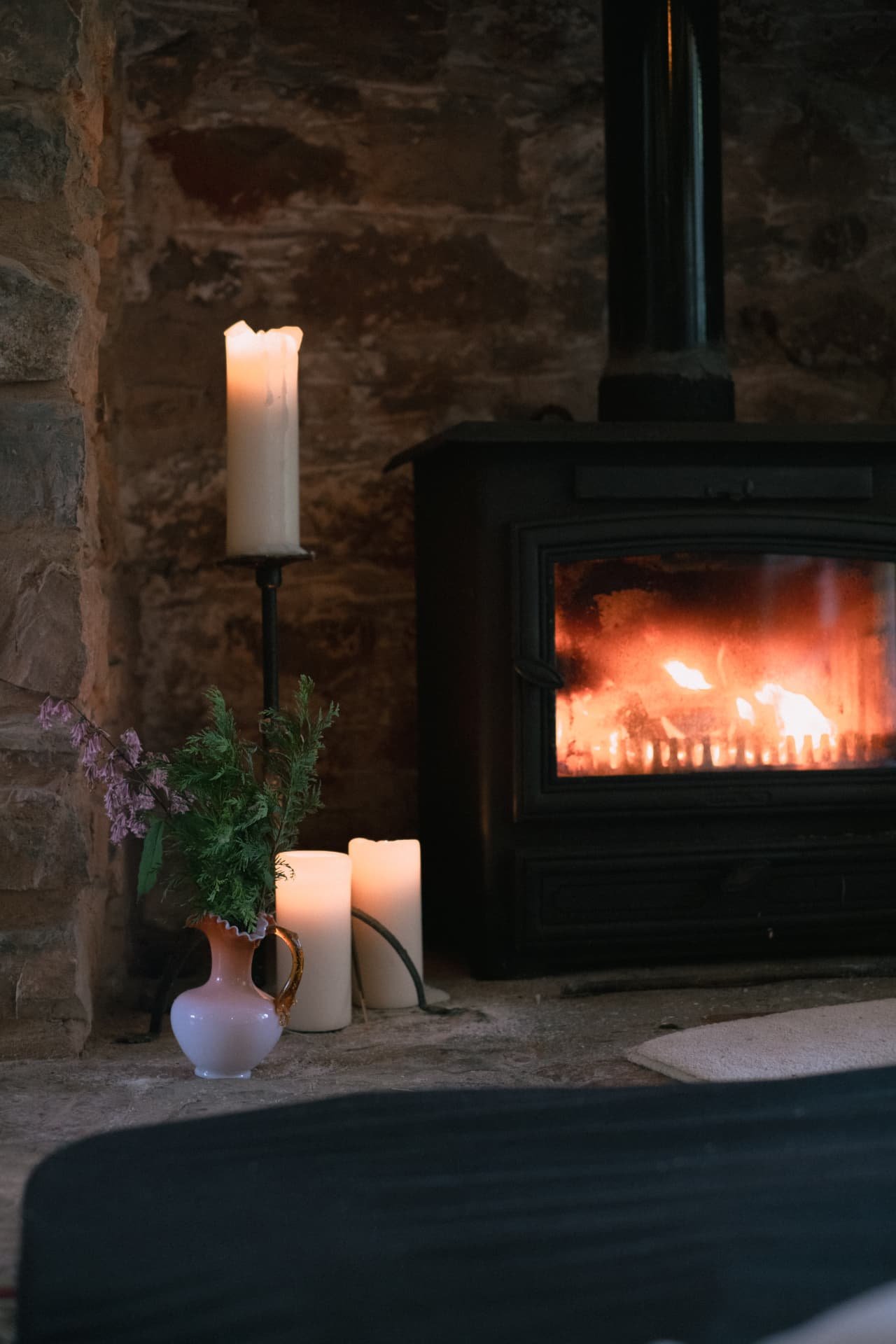 Candles glowing beside the wood-burning stove